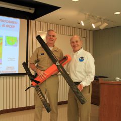 Vice Admiral Devany and Dr. Spinrad pose with the Coyote Unmanned Aerial System. Image credit: NOAA