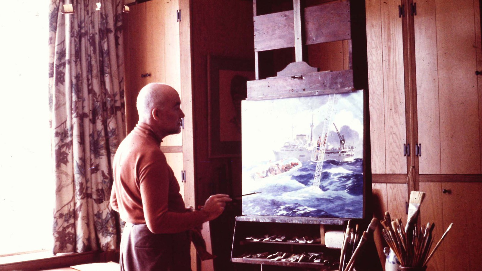 The marine artist Jack Coggins with his oil painting of the Discover and at-sea activities.