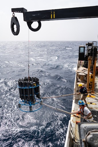 A large black CTD is lowered into the ocean from the NOAA Ron Brown Ship.