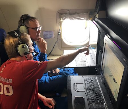 AOML hurricane researchers Trey Alvey (front) and Rob Rogers (back) analyze radar data on a research mission into Hurricane Fiona in September 2022.