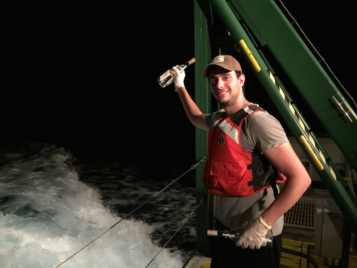 AOML Intern Ciro Liutti gets ready to release a message in a bottle off the back of the F.G. Walton Smith into the Florida Current. Image credit: NOAA