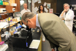 Congressman Diaz-Balart examining an ocean water sample under the microscope. Image credit: NOAA