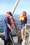 An AOML intern rinses out a bucket used to collect water samples for Ocean Sampling Day 2014. Image credit: NOAA