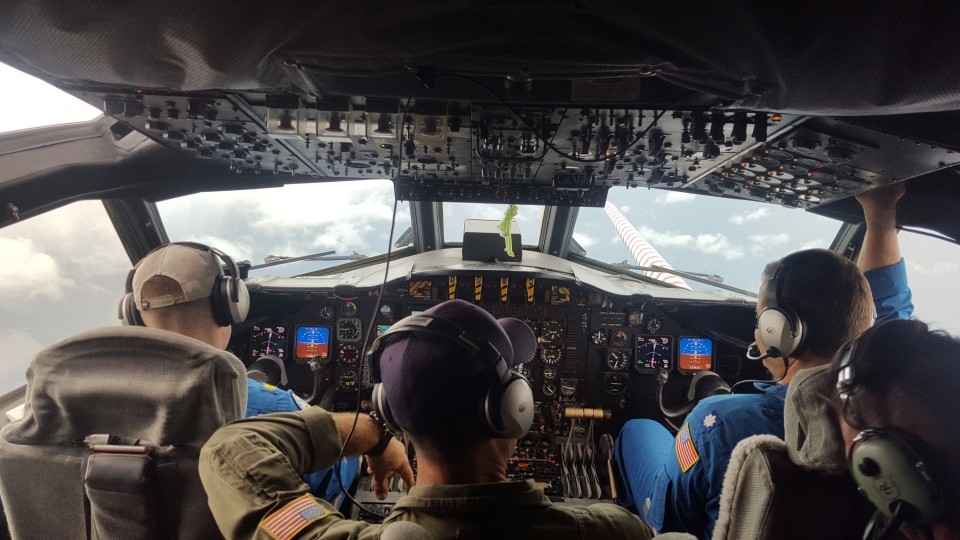 Los cazadores de huracanes se sientan en la cabina del P3 (un avión especializado creado para ser un laboratorio volador). Los pilotos se acercan al ojo de un huracán como se muestra a través de la ventana frontal. Crédito de la foto: NOAA.