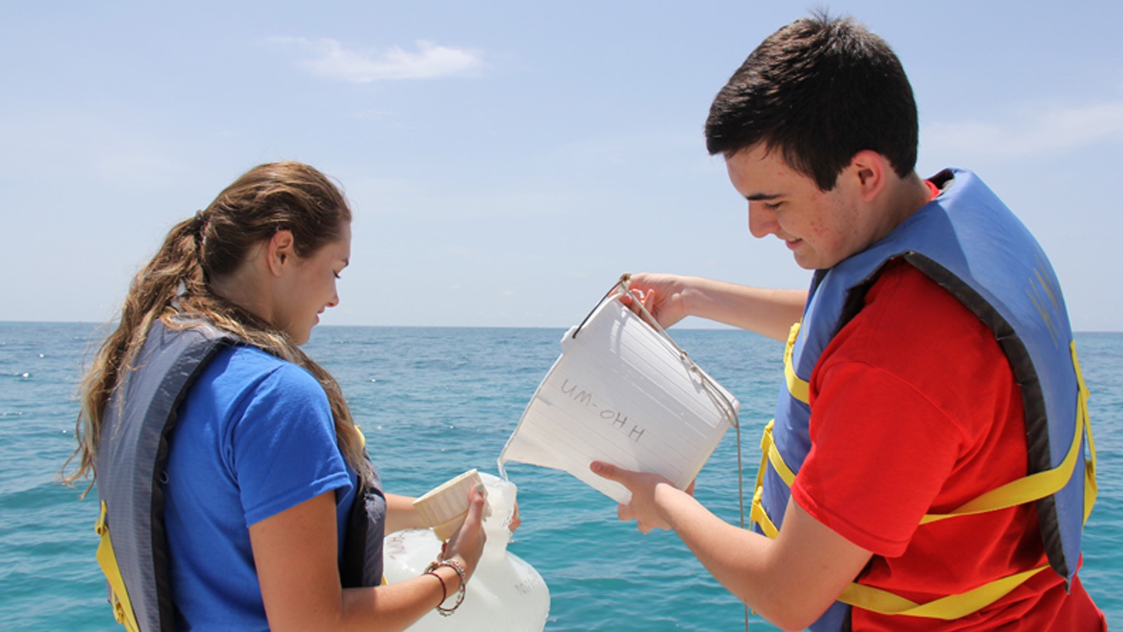 Two AOML interns work to collect a sample off the Florida Keys on Ocean Sampling Day 2014. Image credit: NOAA