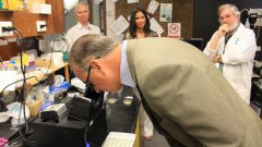 El congresista Diaz-Balart examinando una muestra de agua del océano bajo el microscopio. Crédito de la imagen: NOAA