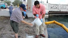 Dr. Chris Sinigalliano cleans out a sampling bottle before taking the final sample. Image credit: NOAA