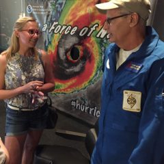 El investigador de huracanes del AOML habla con un visitante del museo. Crédito de la imagen: NOAA