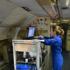 La investigadora de huracanes Lisa Bucci analizando los datos de las tormentas a bordo del avión P-3. Crédito de la imagen: NOAA