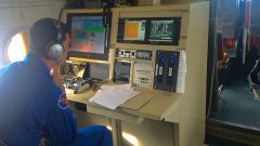 Un investigador de huracanes vigila las condiciones de la tormenta en un puesto de trabajo a bordo del avión P-3. Crédito de la imagen: NOAA
