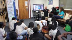 Students listening to a science presentation in the library during Frost Summer Camp. Photo Credit, NOAA AOML.