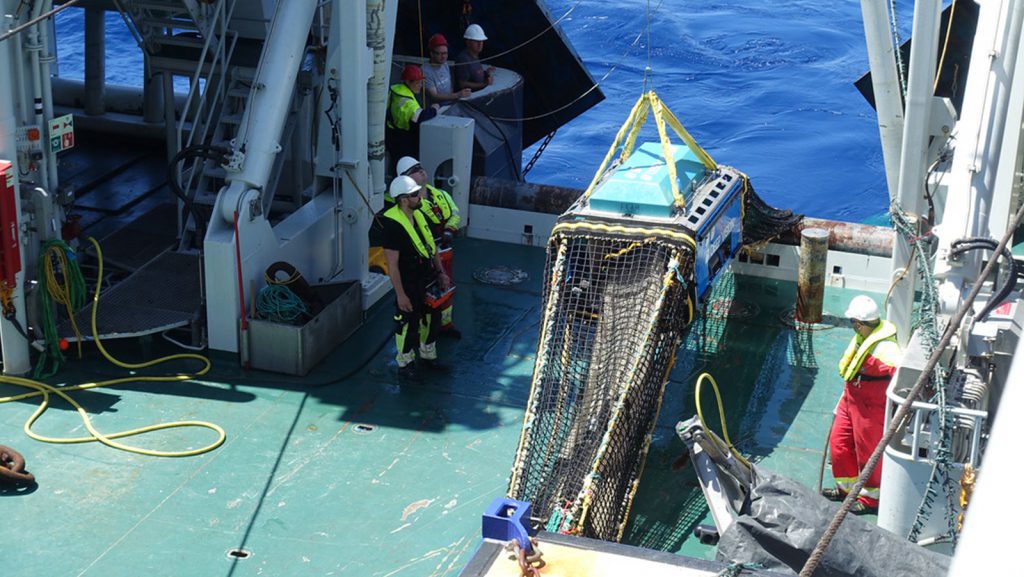 A macroplankton trawl equipped with Deep Vision, a camera system that gathers continuous images of passing organisms, is brought on deck after gathering fish from the mesopelagic zone.