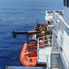 View from the bridge: the winch house peeking out from the ship’s superstructure in the back, the winch boom with the cable going down while the CTD is in the water. Photo Credit: NOAA.