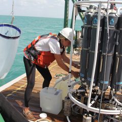 Scientist Kelly Montenero taking water samples from the CTD. Photo Credit: NOAA AOML.
