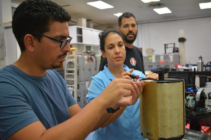 AOML engineer and two CARICOOS members work on a glider during a training in Puerto Rico