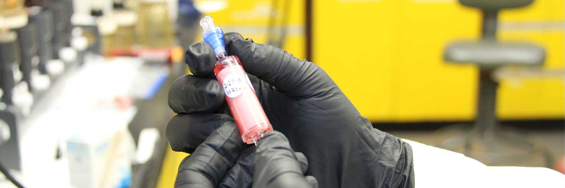 omics researchers in the ocean chemistry & ecosystems division measure DNA, RNA & protein, to understand ecosystem health. Image depicts black gloved hands holding A red translucent inline filter.