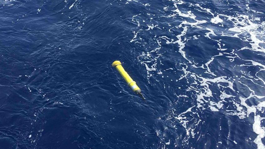 A yellow Argo float floating in the ocean.