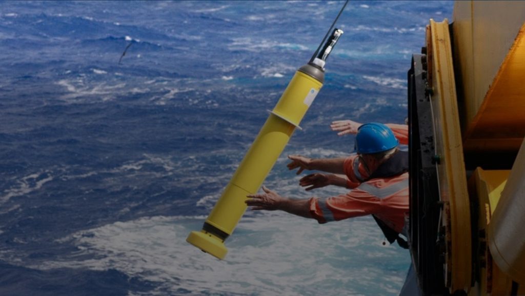 Un gran flotador Argo amarillo es arrojado al océano desde un barco.