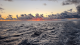 Una vista de la puesta de sol sobre el océano desde el crucero PNE 2021