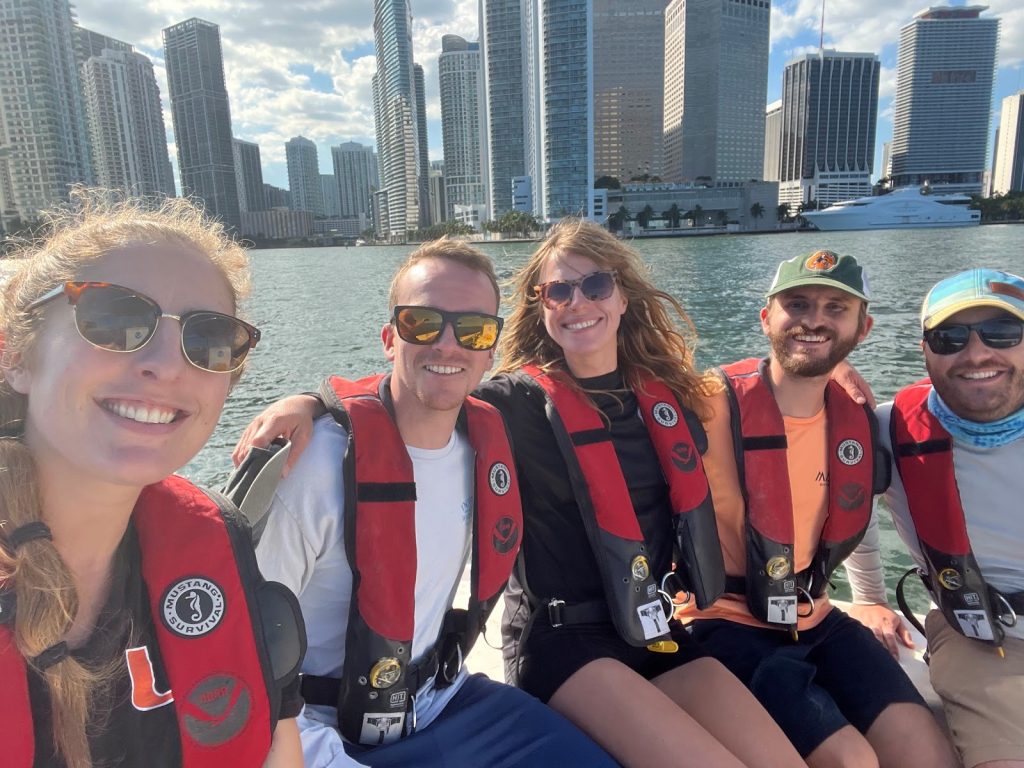 Los investigadores del equipo de campo de Miami en un barco de investigación en la bahía de Biscayne, con el horizonte de Miami a sus espaldas.