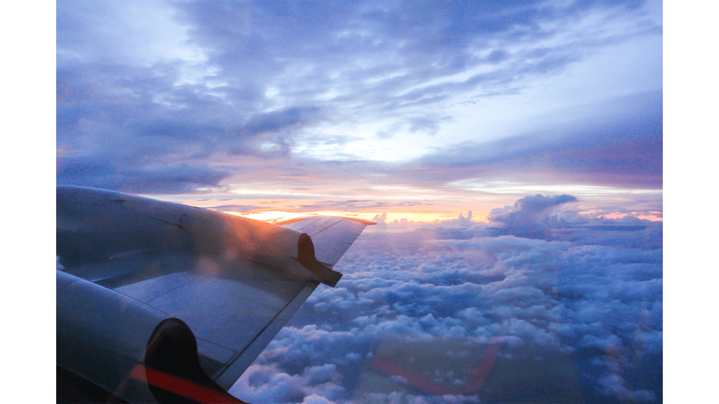 Vista de una puesta de sol, nubes y un ala de un avión Hurricane Hunter.