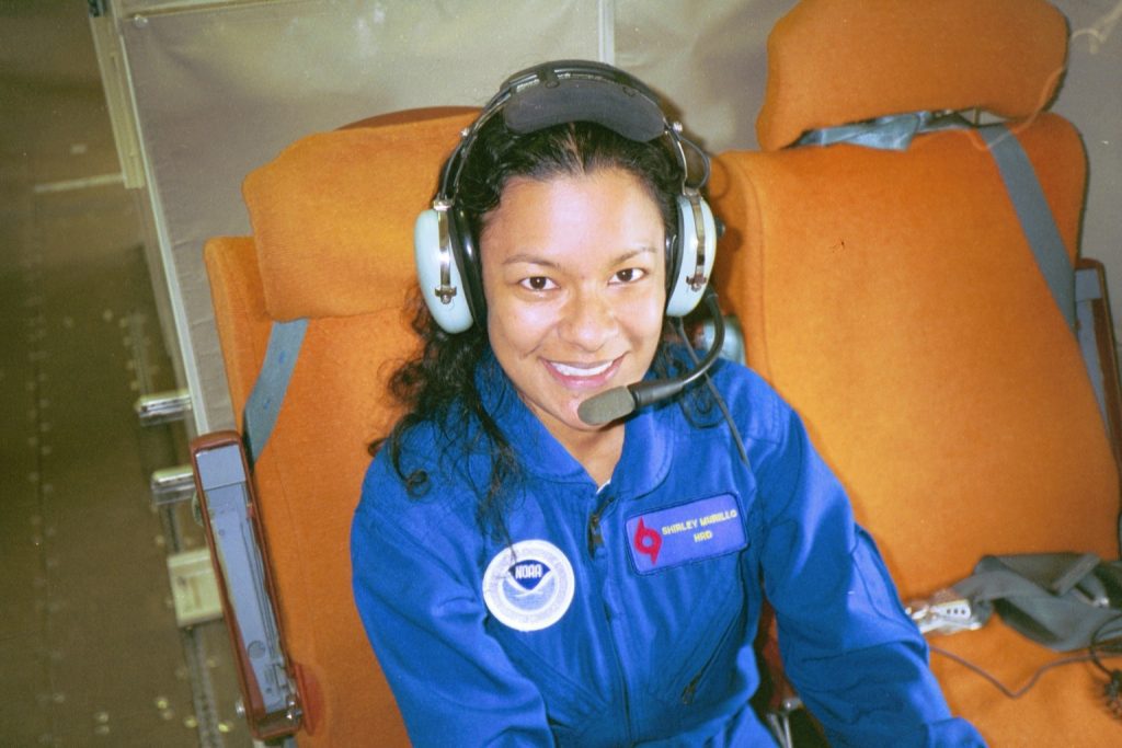 Fotografía en color de la Subdirectora de la División de Investigación de Huracanes, Shirley Murillo, a bordo de un avión Hurricane Hunter de la NOAA.
