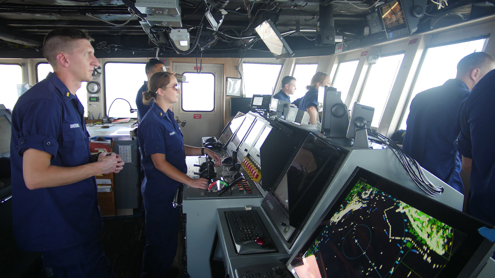 NOAA Corps officers on the bridge of NOAA vessel, Nancy Foster, navigating out at sea.