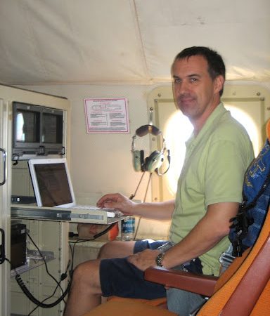 Rob Rogers, meteorólogo del AOML, sentado ante su ordenador a bordo de un avión P-3 Hurricane Hunter de la NOAA.