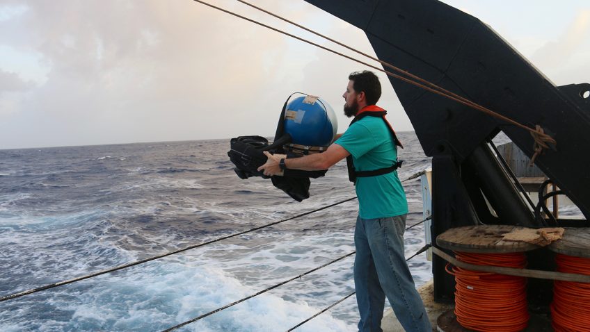 Shaun Dolk throwing a drifter over the side of a ship.