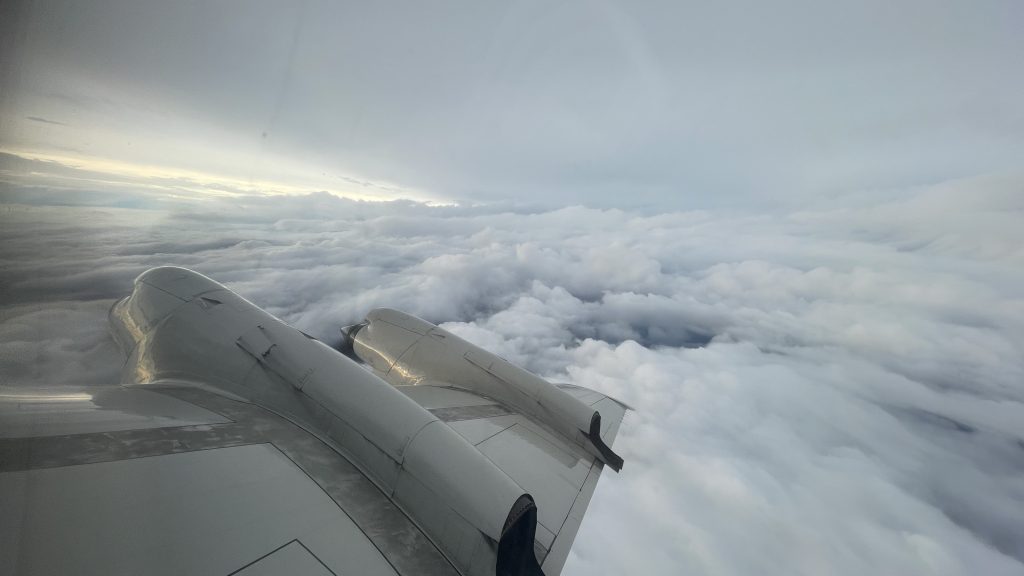 Photograph of the right wing of the NOAA P-3 hurricane hunter aircraft with clouds of hurricane Idalia in the background.