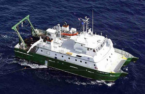 A huge white ship with blue hull on calm sea